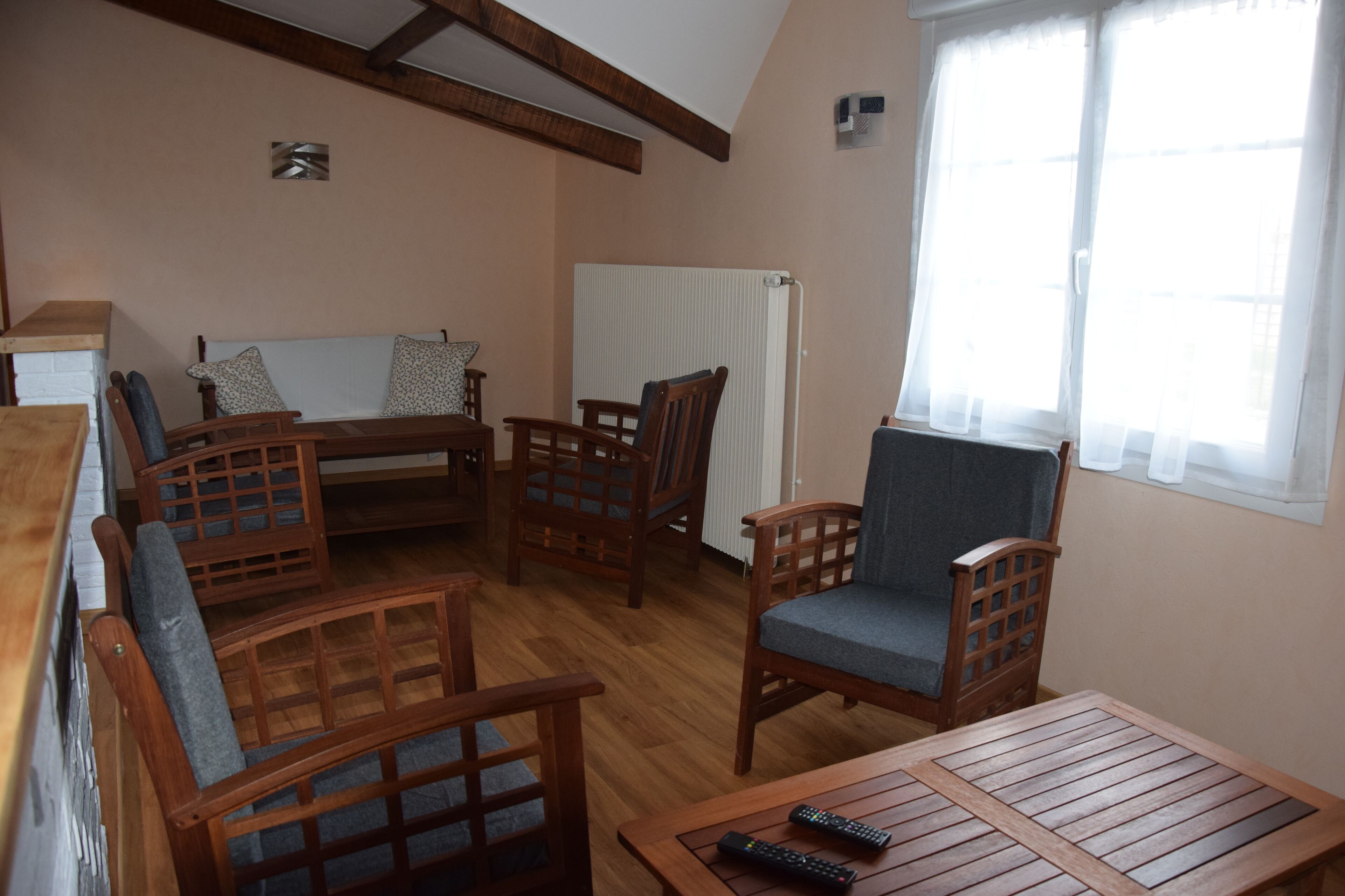 A cozy room with wooden furniture, including a sofa, chairs, and a table.