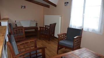 A cozy room with wooden furniture, including a sofa, chairs, and a table.