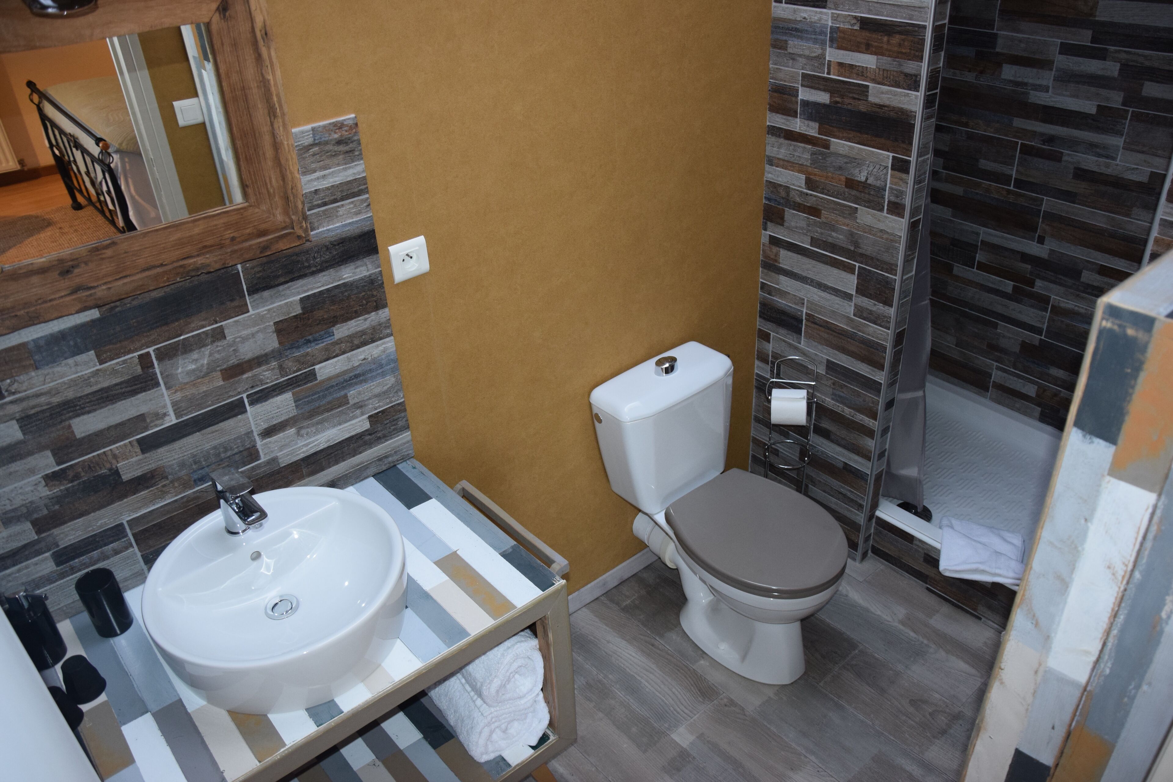 A bathroom with a white sink, a toilet, and a shower area.