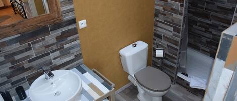 A bathroom with a white sink, a toilet, and a shower area.