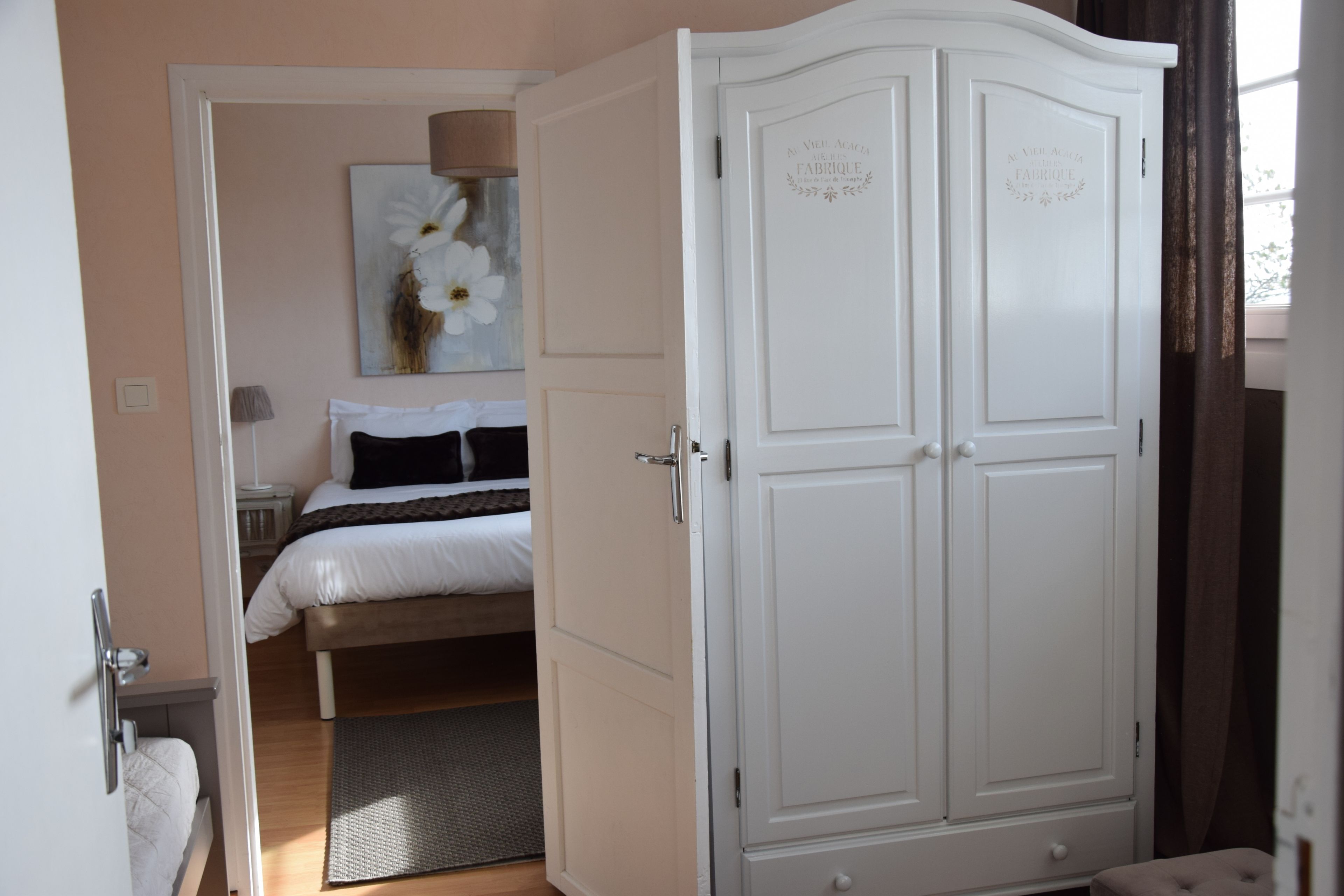 Ein Schlafzimmer mit einem Bett, einem Kleiderschrank und einem Gemälde an der Wand.