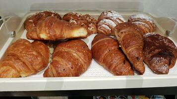 Una vitrina con diversos tipos de pasteles y productos alimenticios envasados.