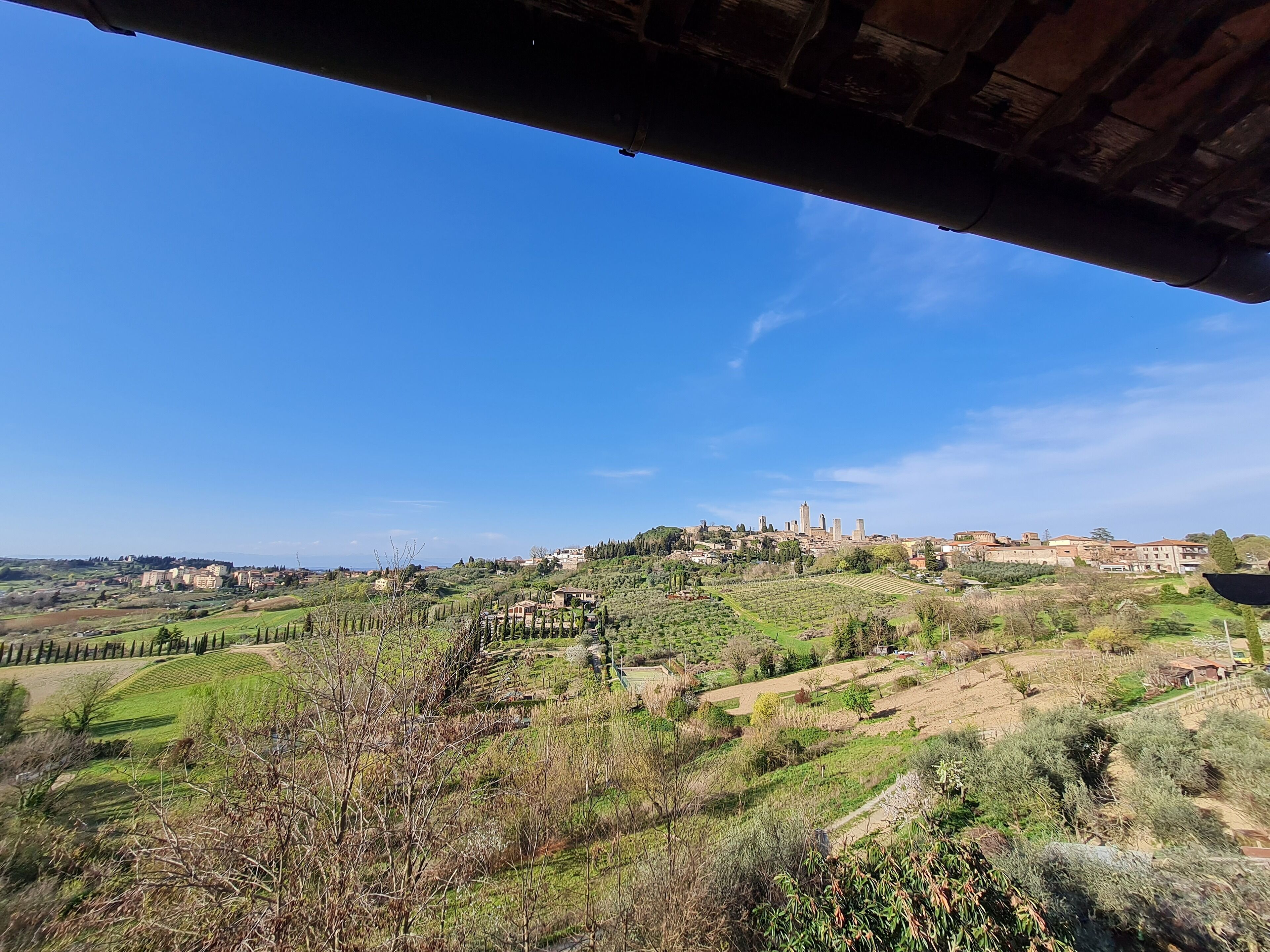 A view of a hillside town with buildings and fields.