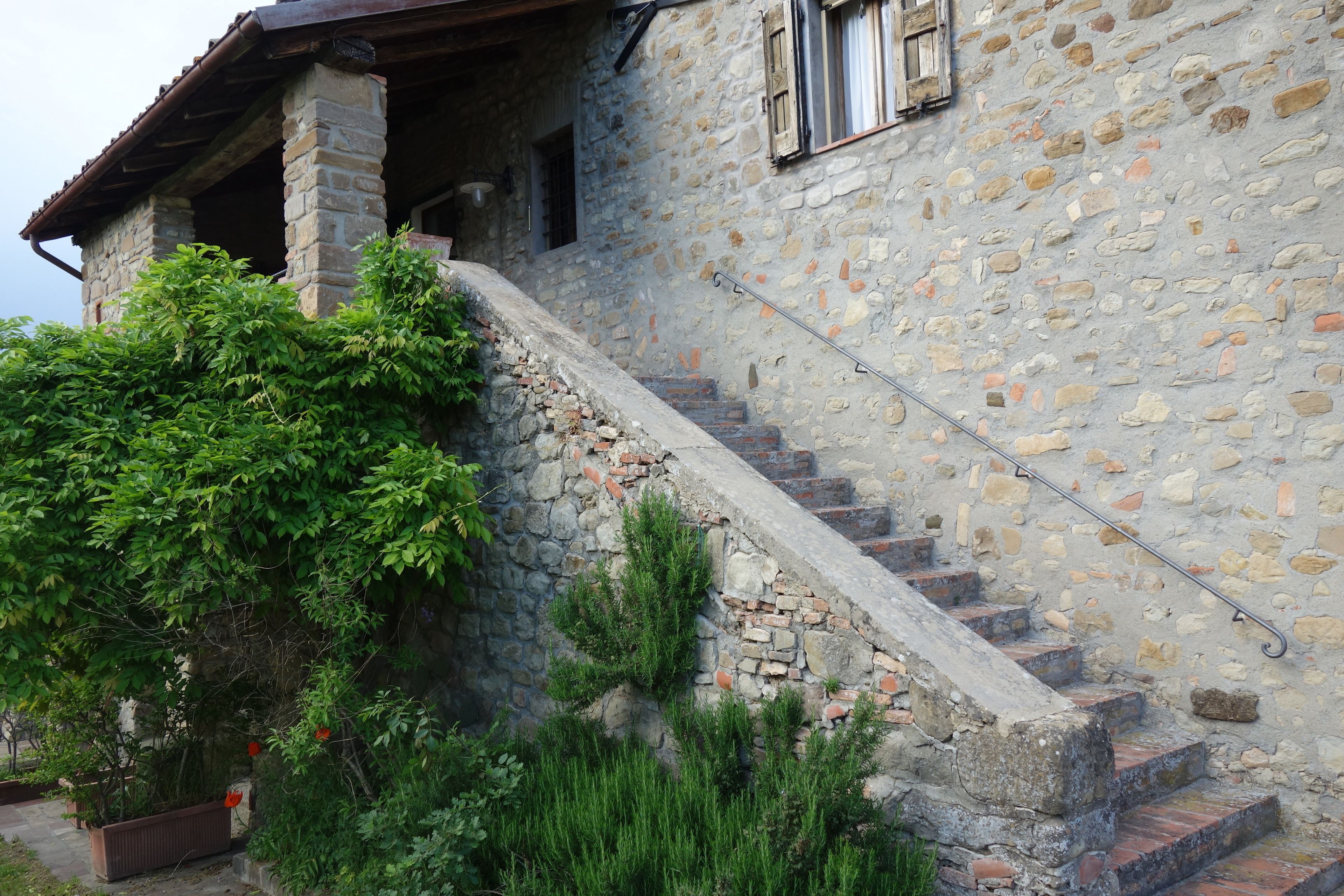 Un edificio de piedra con una escalera que conduce a una puerta de madera.