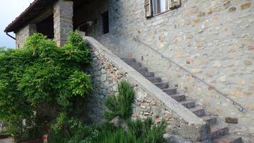 Un edificio de piedra con una escalera que conduce a una puerta de madera.