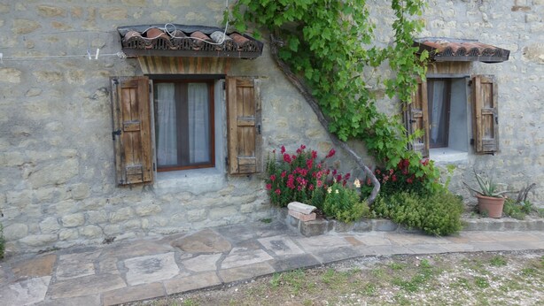 A stone building with two windows, each with wooden shutters and a small flower box. - Bed and breakfast Monte Bibele (Monterenzio)