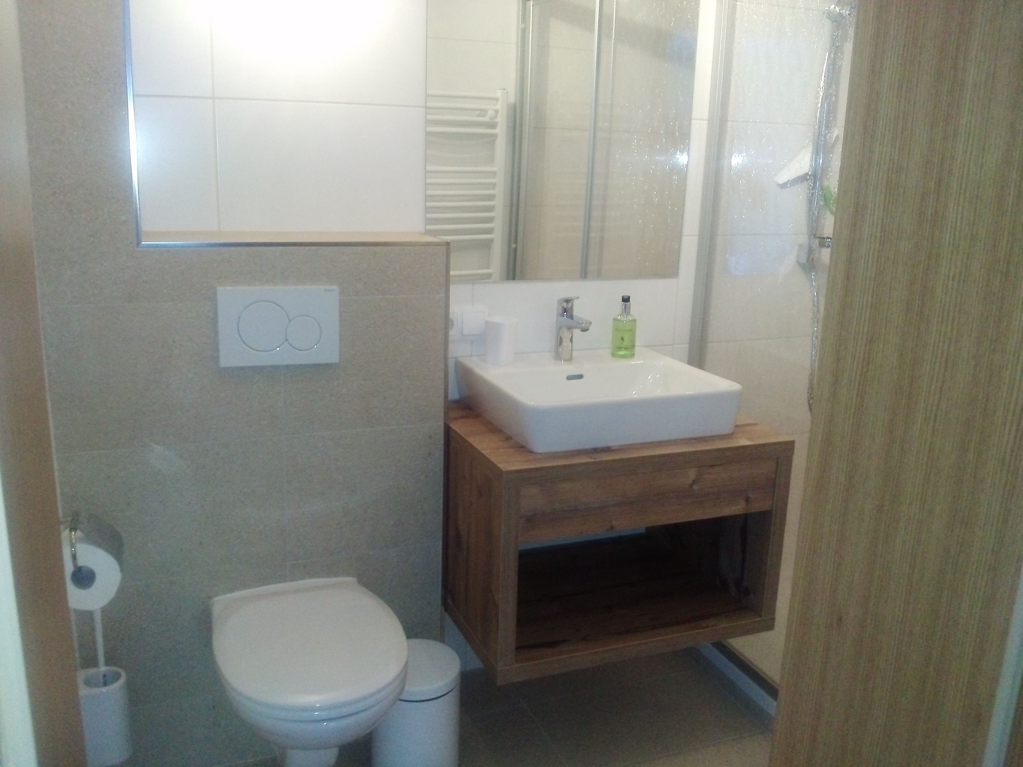 Une salle de bain avec des toilettes, un lavabo et une douche.