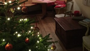 A cozy living room with a Christmas tree, wooden furniture, and a window with curtains. - Haus Alpenrose (Waidring)