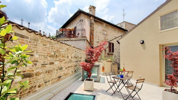 Une cour avec une piscine, un espace salon extérieur et un mur en pierre.