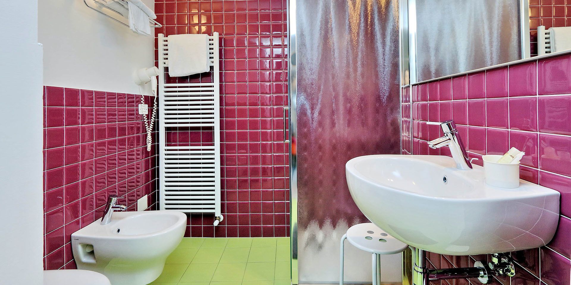 Ein Badezimmer mit einem Bidet, einem Waschbecken und einem Handtuchhalter.