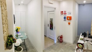 Pasillo de hotel con zona de comedor, extintor y varios carteles, incluyendo WiFi y prohibido fumar.