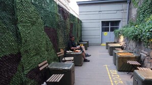 A courtyard with seating areas and a green wall.