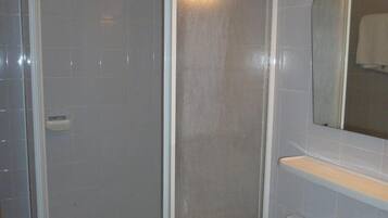 A bathroom with a shower, a sink, and a mirror.