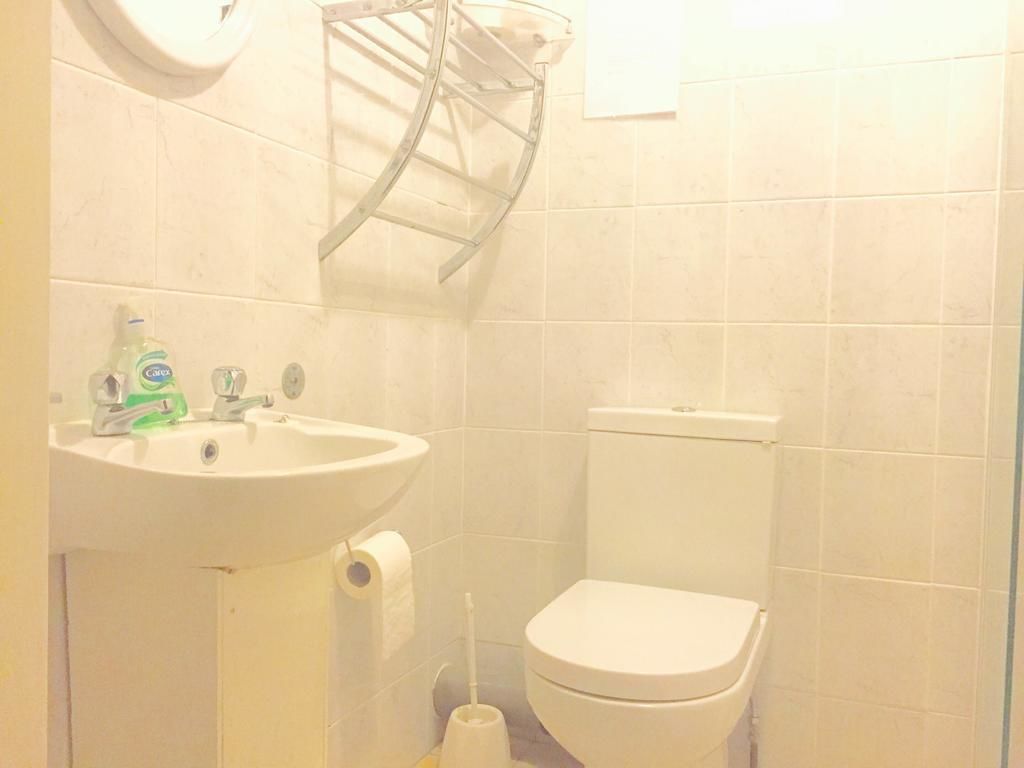A bathroom with a white sink, toilet, and a towel rack.