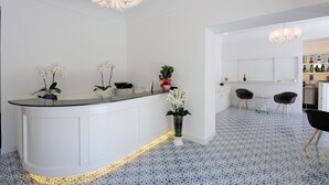 Une cuisine moderne avec des meubles blancs, un îlot central et un coin repas équipé de deux chaises.
