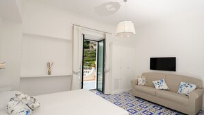Une chambre avec un lit, un canapé, une télévision et une vue sur l’extérieur.