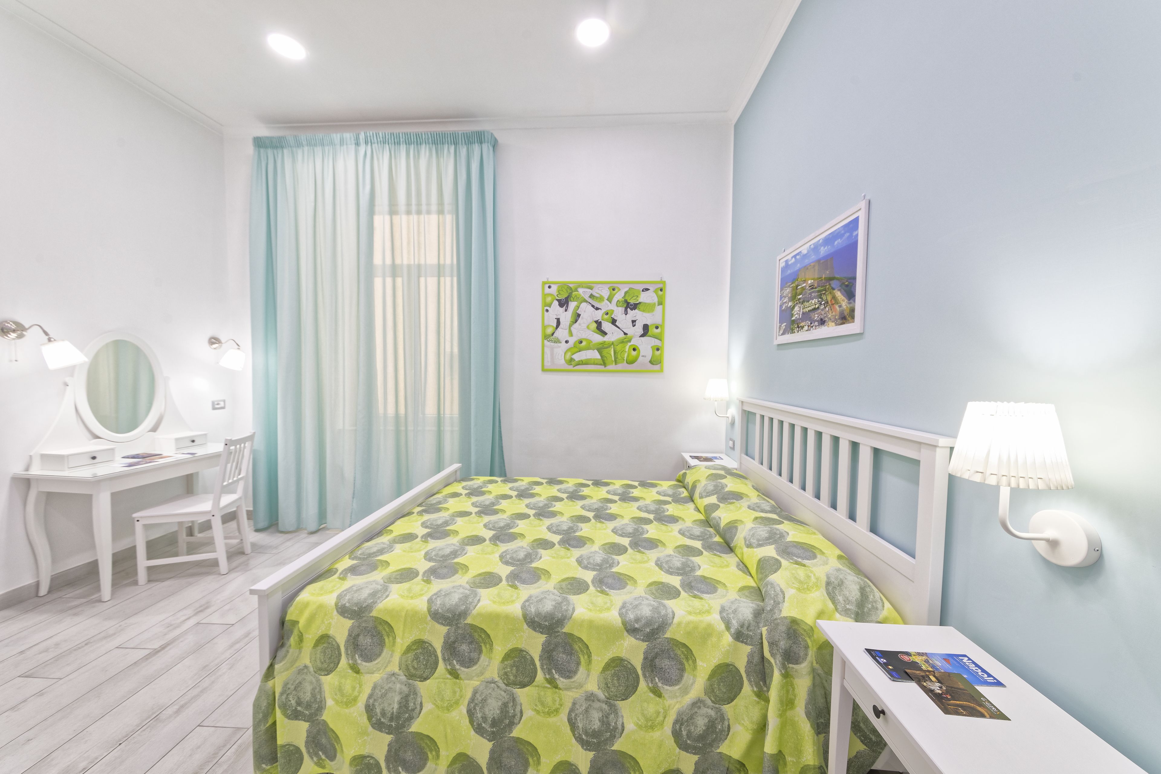 Ein Schlafzimmer mit Bett, Schreibtisch, Stuhl, Spiegel und Nachttisch.