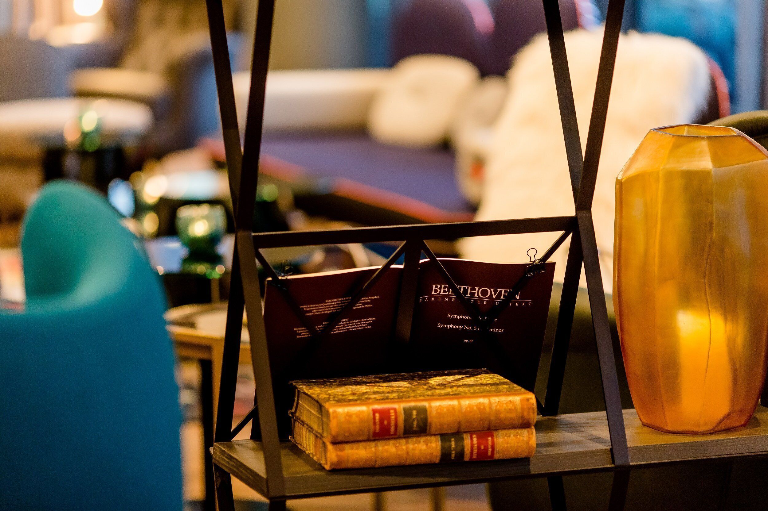 A table with a stack of books, a decorative vase, and a bag with text.