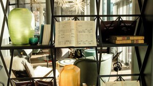 A bookshelf with sheet music, books, and decorative items. - Motel One Bonn-Beethoven (Bonn)