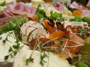 Une planche de charcuterie avec divers types de viandes, de fromages et de garnitures.