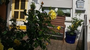 A building facade with a mural, a yellow door, and a bench. - Ferienhaus am Schloss Sayn (Bendorf)