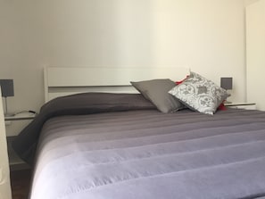A bed with a headboard, two bedside tables with lamps, and a pillow with a patterned design. - The Artist Home Catania Centro (Catania)