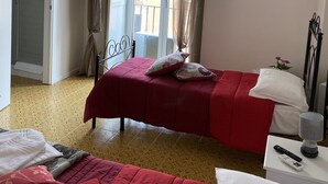 Habitación de hotel con dos camas, ducha, un cuadro en la pared y vistas por la ventana.