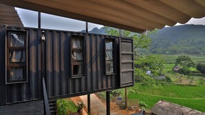 Un edificio moderno de estilo contenedor con amplias ventanas y vistas a un paisaje verde y exuberante.