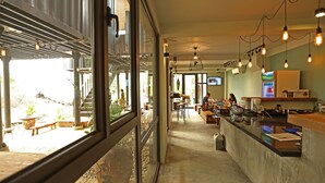 Un espacio interior con mostrador, zona de estar y vistas al exterior a través de amplios ventanales.
