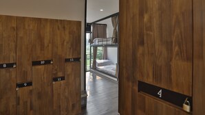 Una habitación de hotel con armarios de madera, una cama litera y vistas por una ventana.