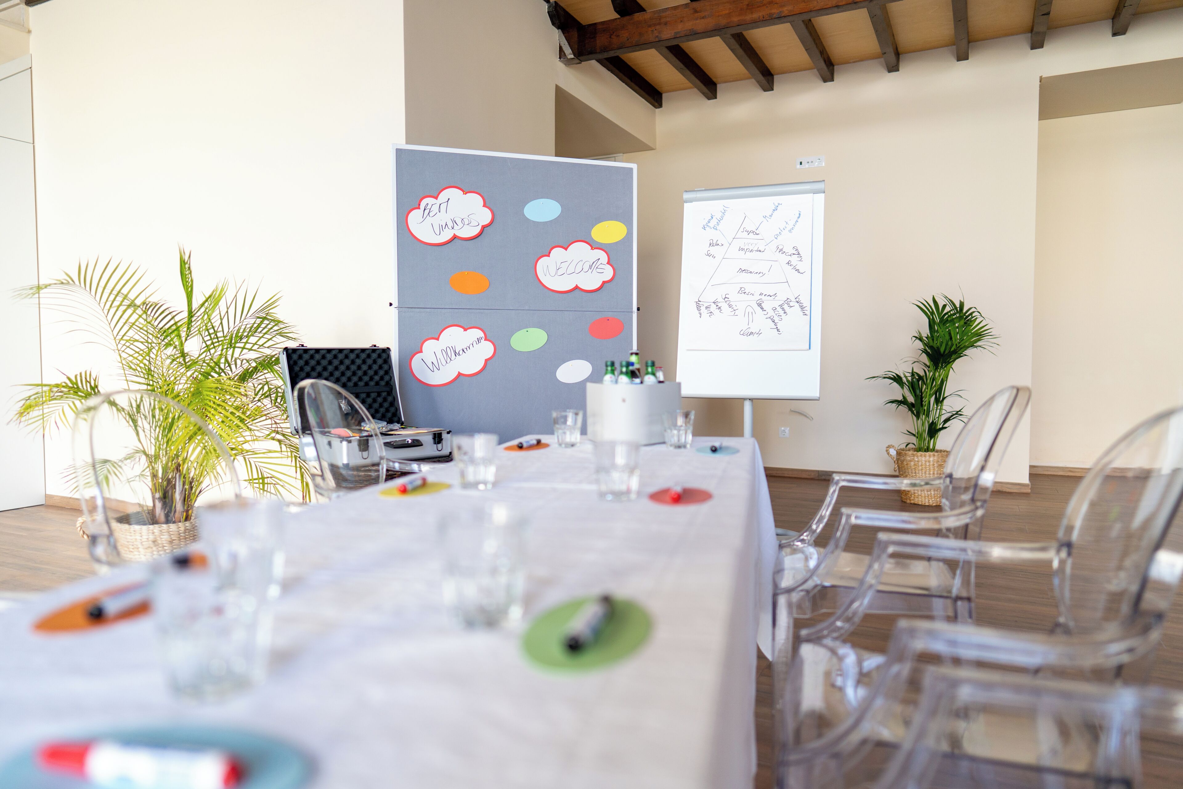 A conference room with a long table, chairs, a whiteboard, and decorative wall stickers.