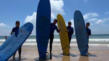 A beach scene with people holding surfboards.