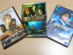Tres cajas de DVD sobre una superficie de madera.