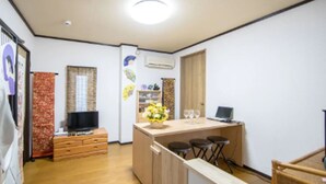A compact kitchen with a wooden countertop, a television, and a laptop. - Sakura Inn (Kyoto)
