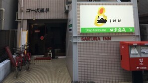 A building with a sign for Sakura Inn, featuring a staircase and a tiled facade. - Sakura Inn (Kyoto)
