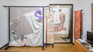 A room with a sliding shoji screen, a traditional Japanese sliding door, and a television on a wooden dresser. - Sakura Inn (Kyoto)