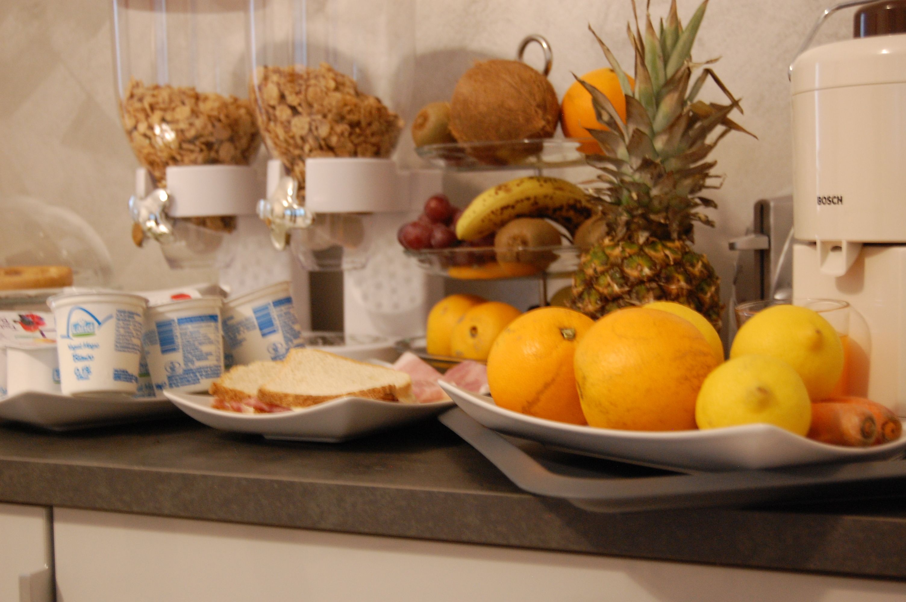Un buffet de petit-déjeuner proposant une variété d’aliments, notamment du pain, des fruits et des boissons.