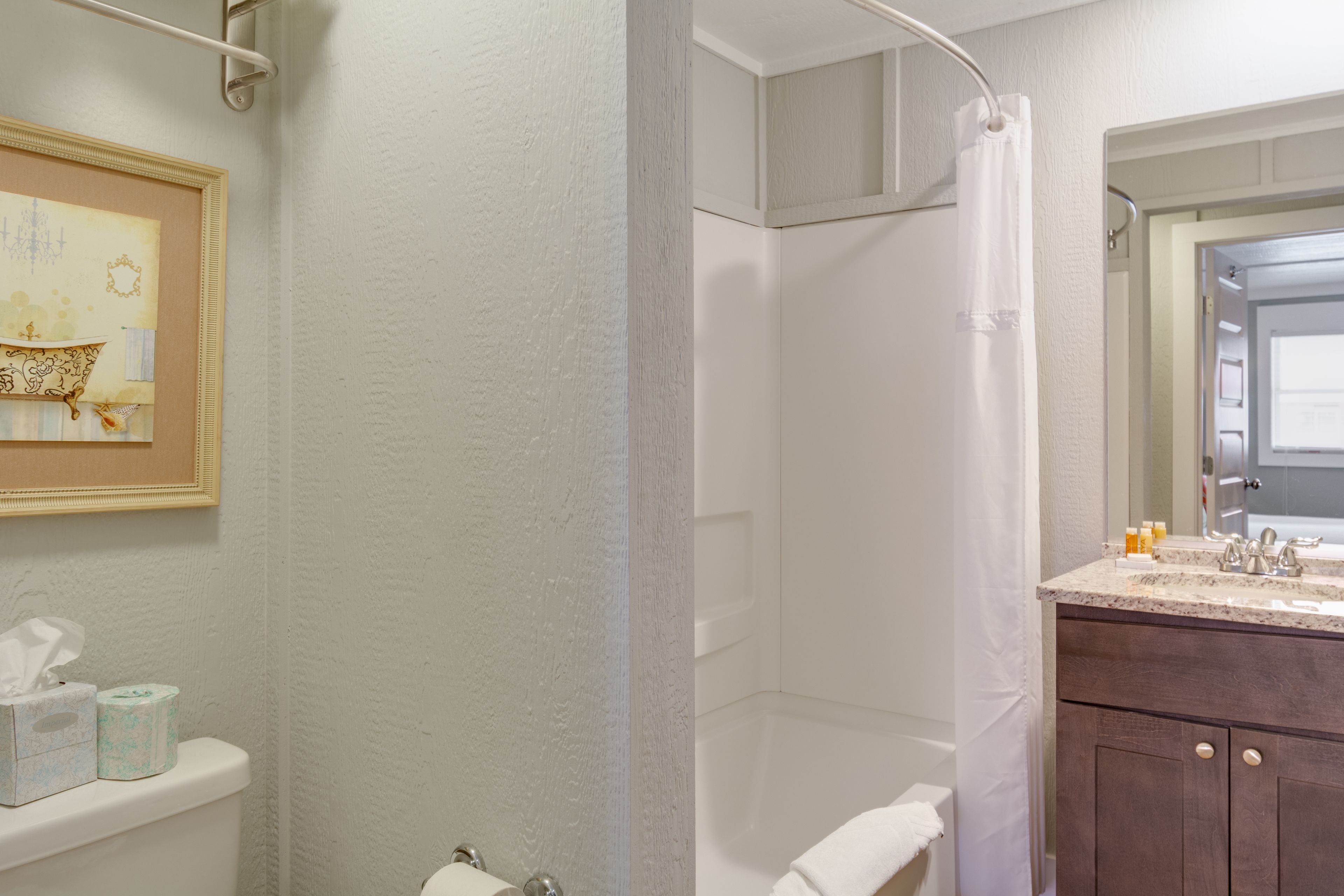 Een badkamer met douche, toilet en wastafel.