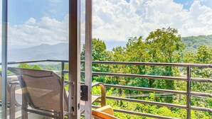 Ein Balkon mit Metallgeländer, einem Stuhl und einem Tisch.
