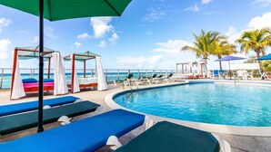 A poolside area with lounge chairs and umbrellas, a clear view of the ocean, and a pool. - Approved  Rooftop Penthouse St Lawrence Gap. (St Lawrence Gap)