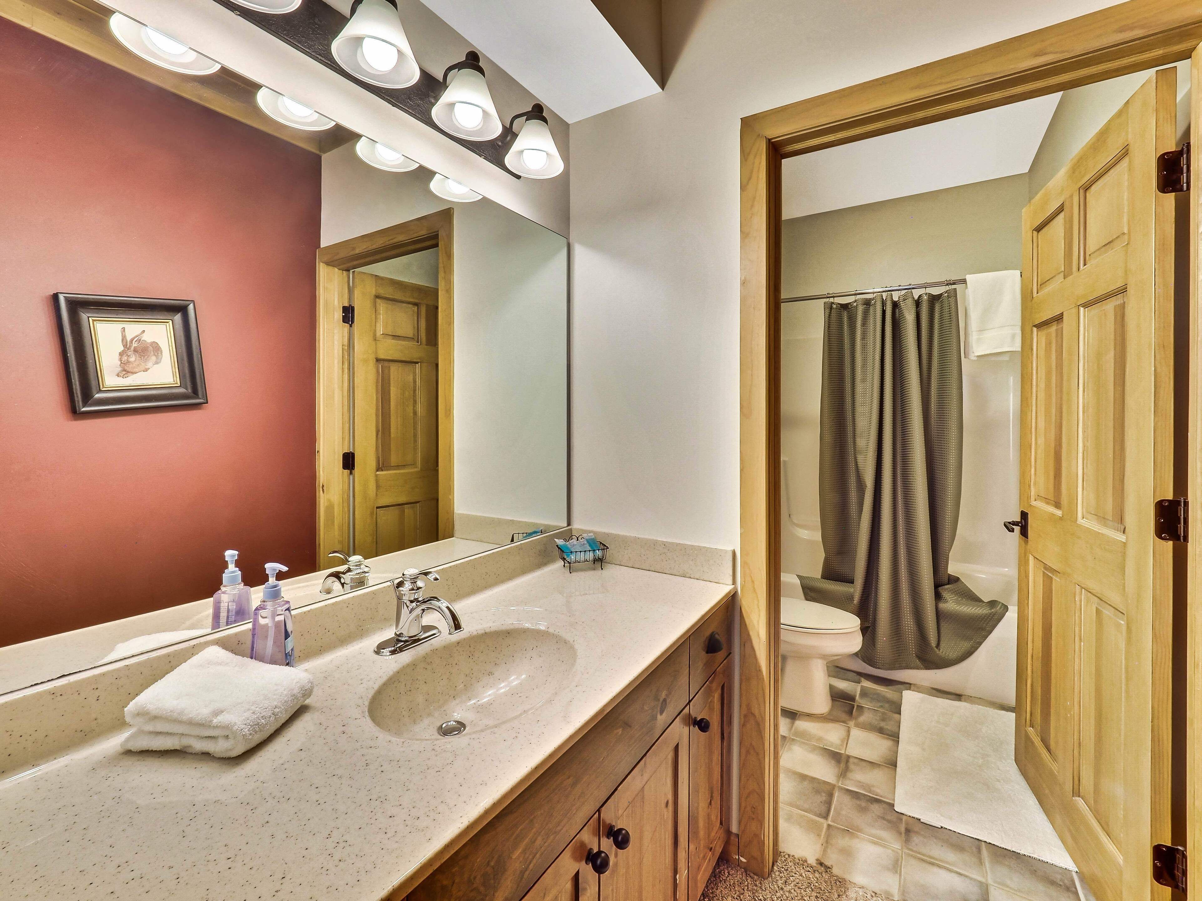 A bathroom with a sink, mirror, and wooden cabinets.