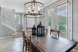 Enjoy meals in this dining area with a table for four, a chandelier, and comfortable seating.