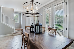Enjoy meals in this dining area with a table for four, a chandelier, and comfortable seating.