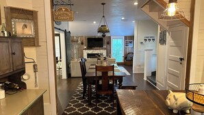 A cozy kitchen with wooden cabinets, a dining area with a bench, and a front porch. - Country Cottage Hideaway near Lynchburg  (Fayetteville)
