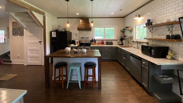 A kitchen with a central island, wooden stools, a coffee machine, and a microwave. - Country Cottage Hideaway near Lynchburg  (Fayetteville)