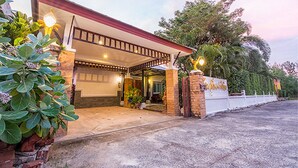 Una casa moderna con un porche cubierto, un garaje y un jardín bien cuidado.
