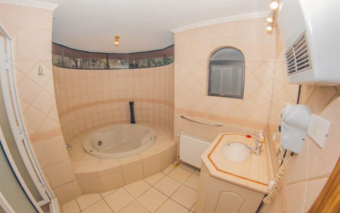 A bathroom with a bathtub, a sink, a mirror, and a towel rack.