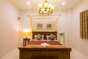 A neatly made bed with a canopy, a bedside lamp, and two framed pictures on the wall. - Baan Sod Sai HuaHin Pool Villa (Hua Hin)