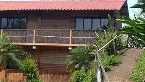 Un edificio de madera con techo rojo y un balcón de madera.