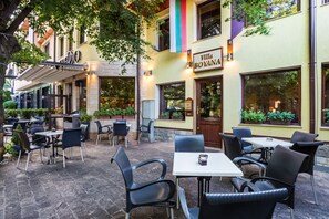 An outdoor patio area with tables and chairs, a sign for 'Villa Boyana', and potted plants. - Hotel Villa Boyana (Sofia)